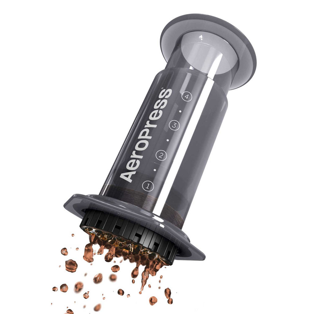 AeroPress Original tilted with the filter cap off and coffee grounds falling out.