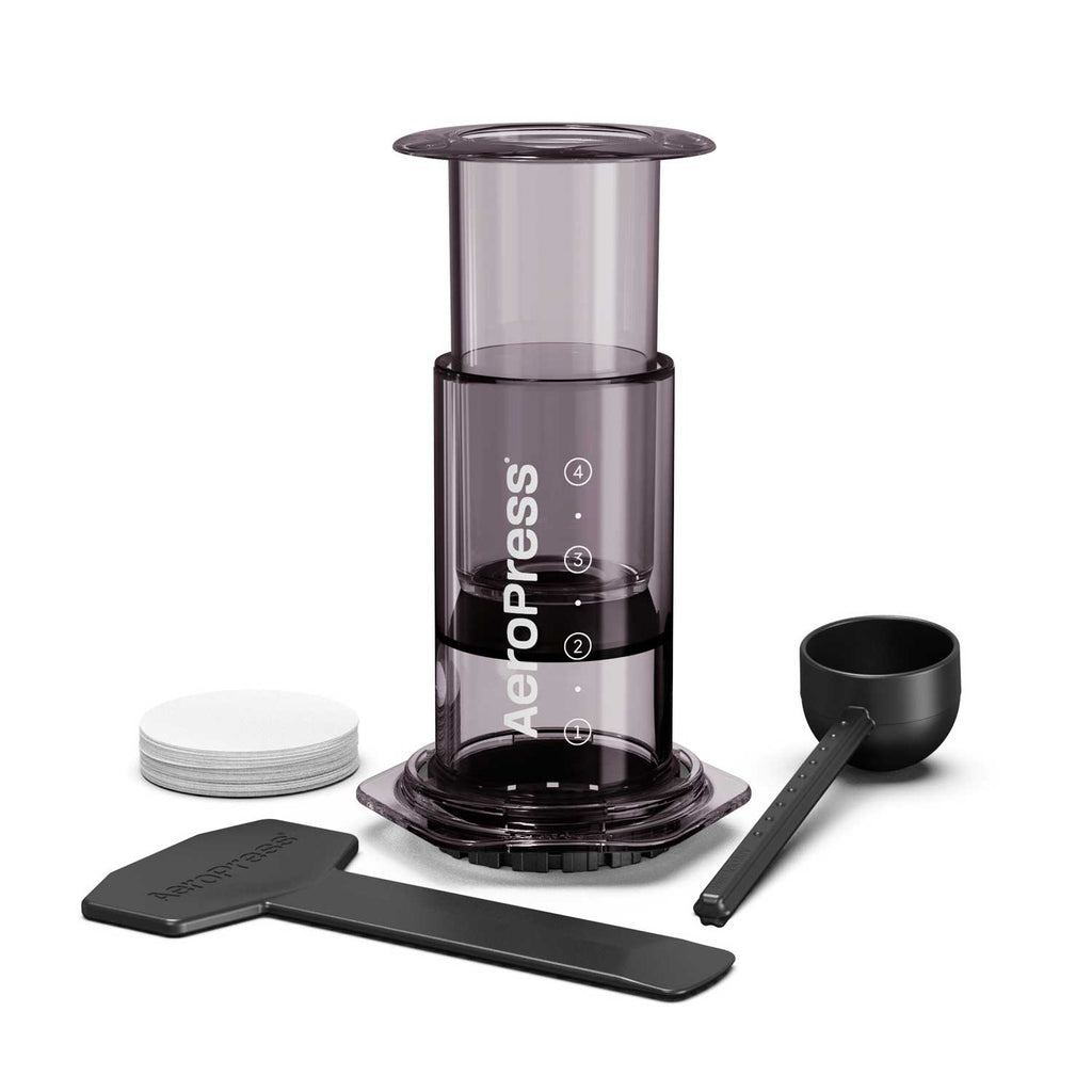 AeroPress Original shown with paper micro-filters, a measuring scoop, a stirrer and a funnel.