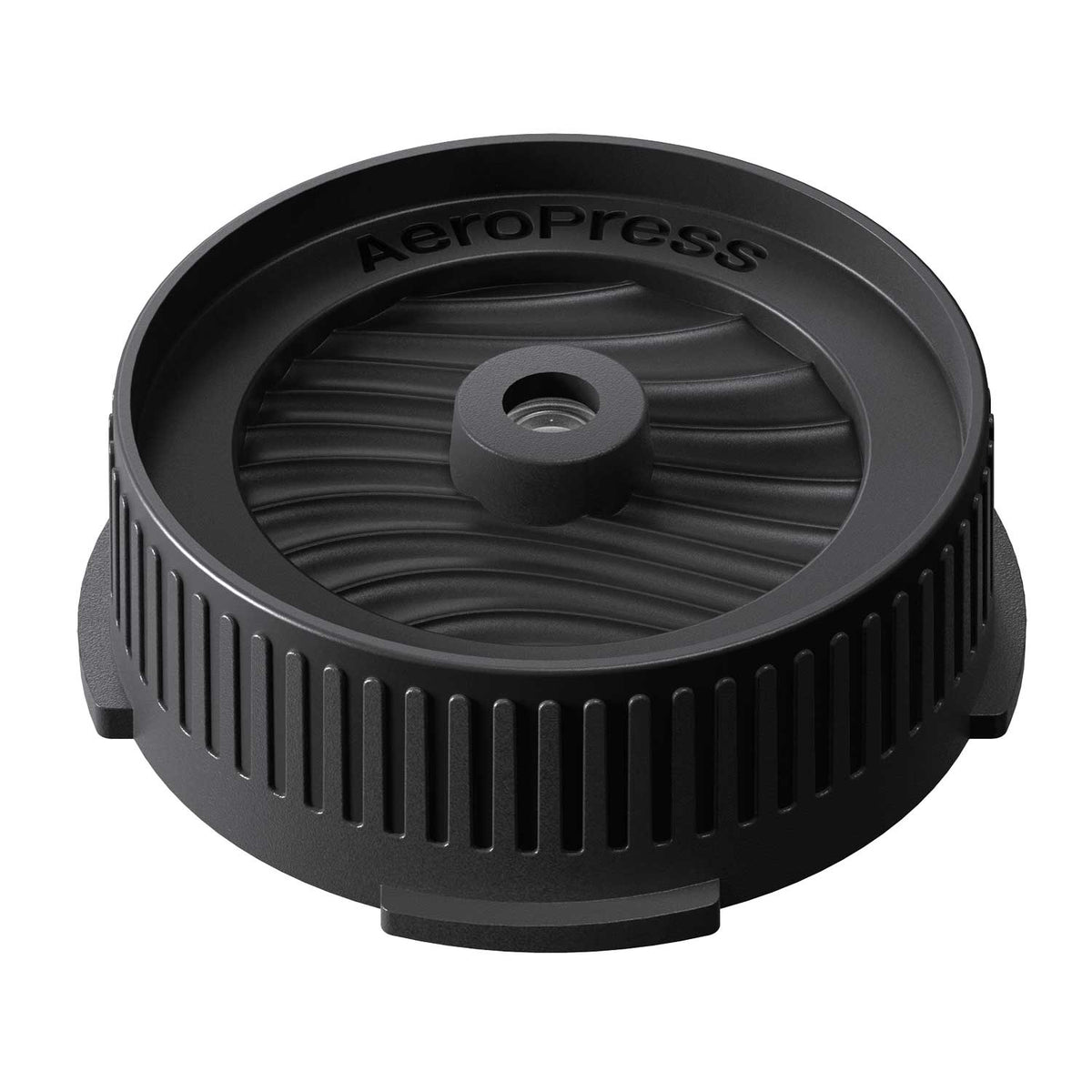 Angled view of the AeroPress Flow Control Filter Cap showing its ribbed body and wave-patterned top.