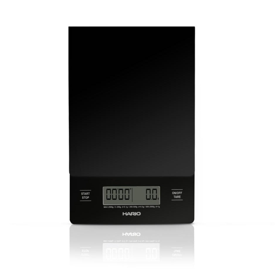 Black Hario V60 drip scale and timer with its LCD display, on a dark background.