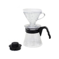 Hario V60 02 pour-over starter kit: clear V60 02 dripper, glass range server with black handle, and black measuring scoop.