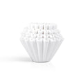 Stack of white Kalita Wave 185 paper filters on a white background.