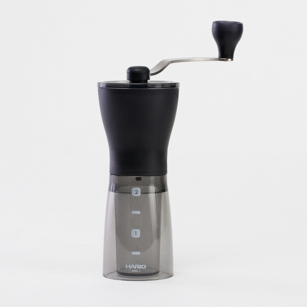 Hario Mini Slim+ assembled hand grinder with crank and marked grounds container